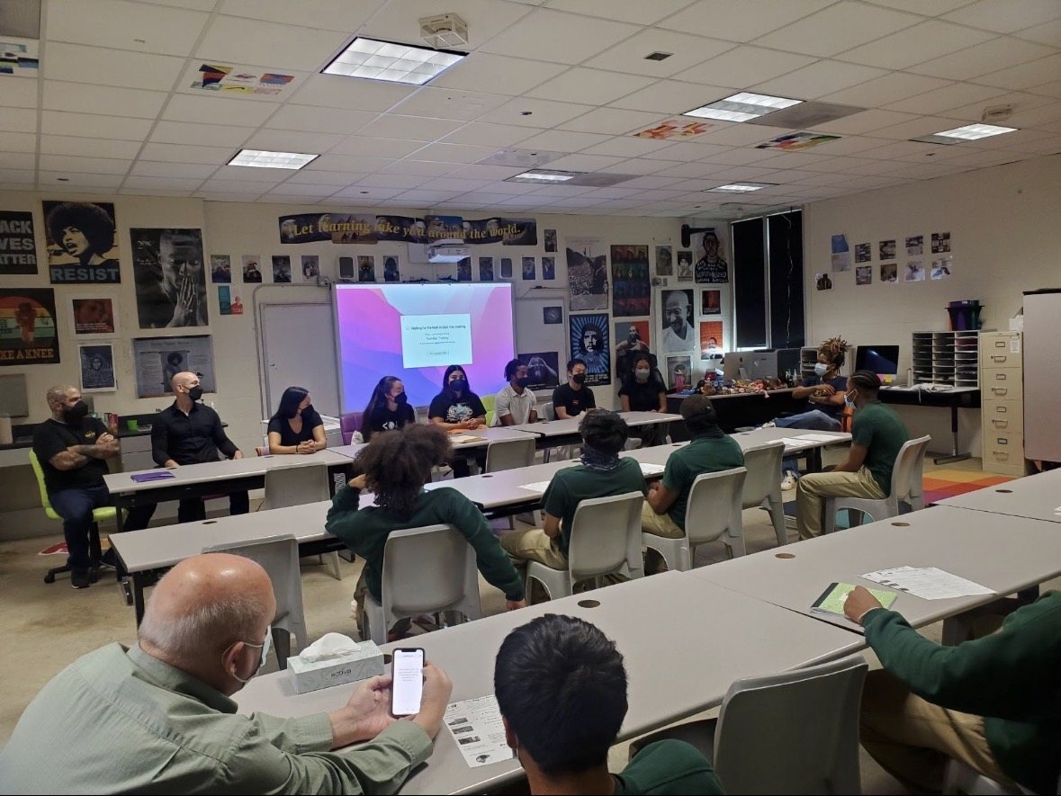 Students participating in a classroom dialogue with community speakers